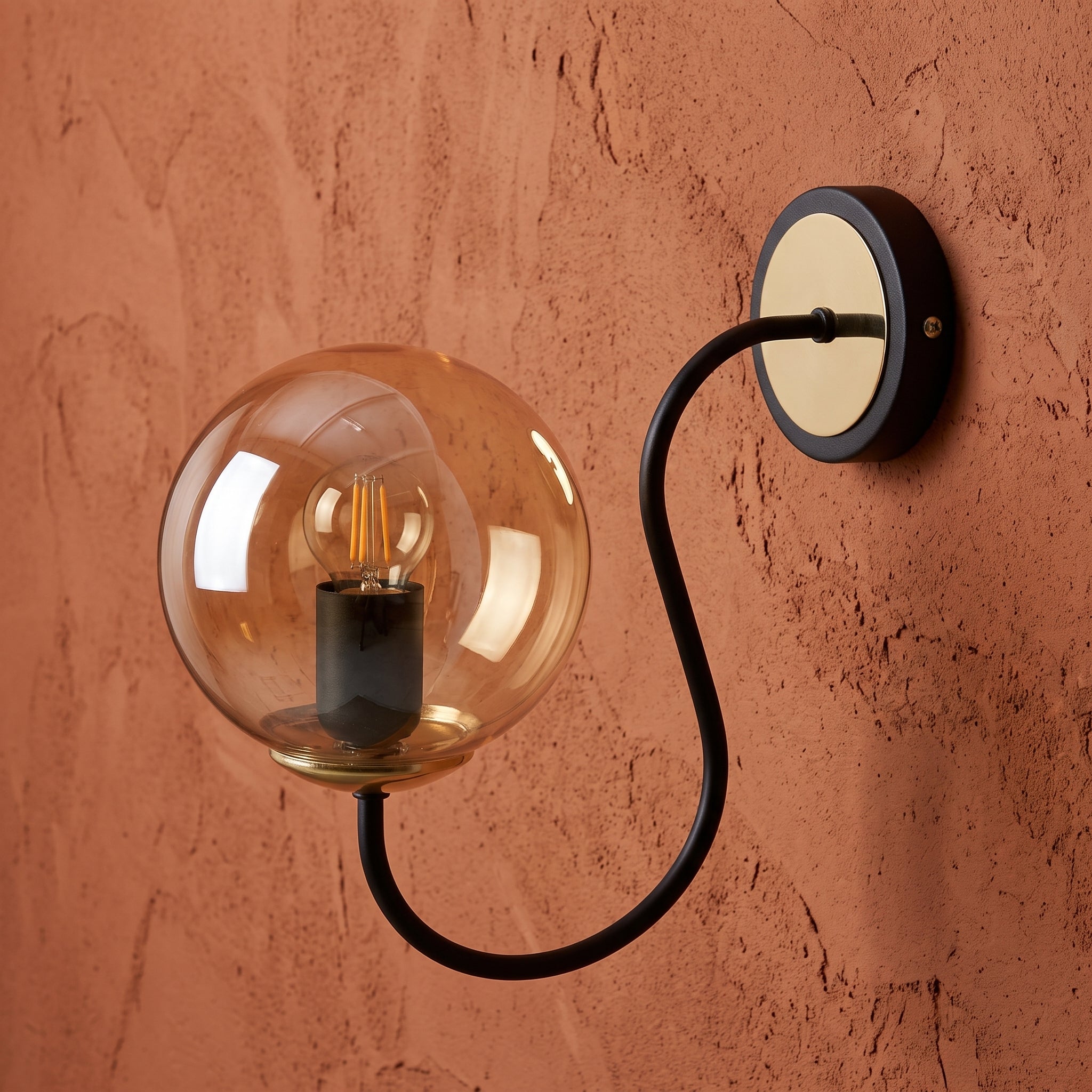 Applique murale globe ambré bras courbe noir mat détails dorés design moderne IP40