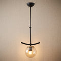 Suspension globe ambré structure noire détails dorés design moderne