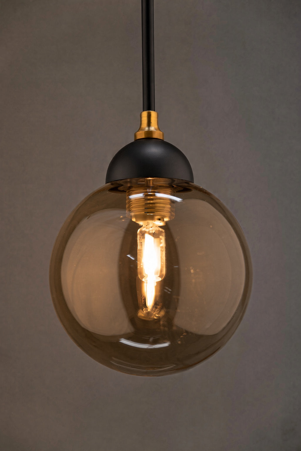 Détail du globe en verre fumé, de la monture noire et de la finition dorée