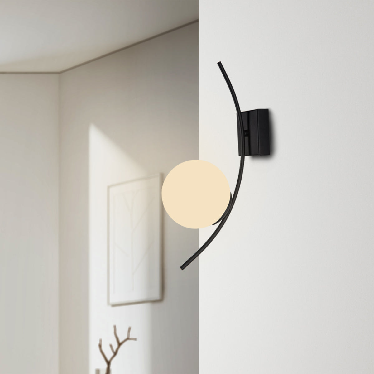 Applique murale à arc noir et globe blanc opale installée sur un mur clair