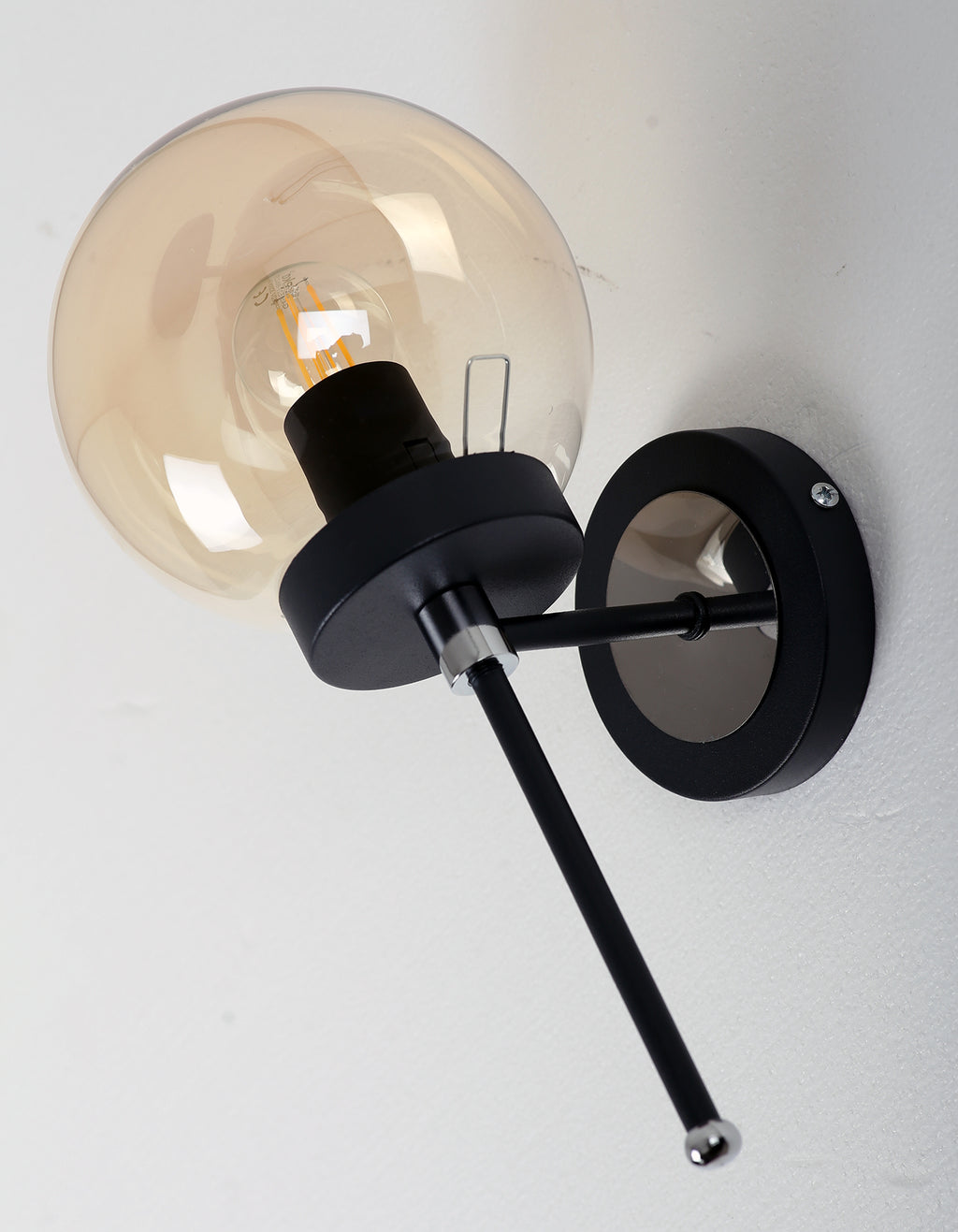 Vue de profil de l'applique murale globe ambré avec structure noir mat et finitions chromées