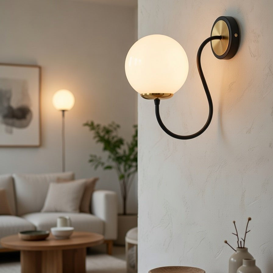 Applique murale globe blanc opale noir et doré installée dans un intérieur contemporain