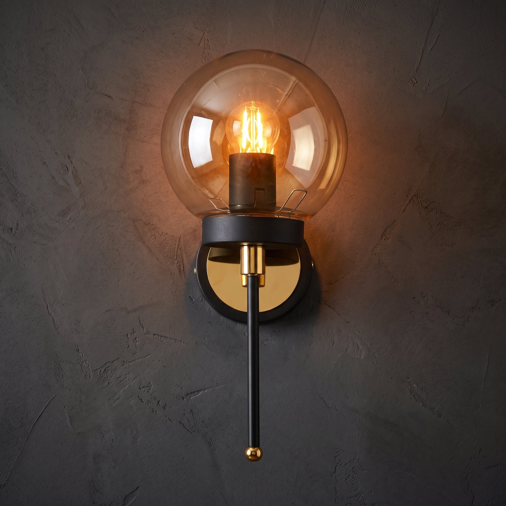 Applique murale globe ambré transparent structure noire détails dorés design luxe