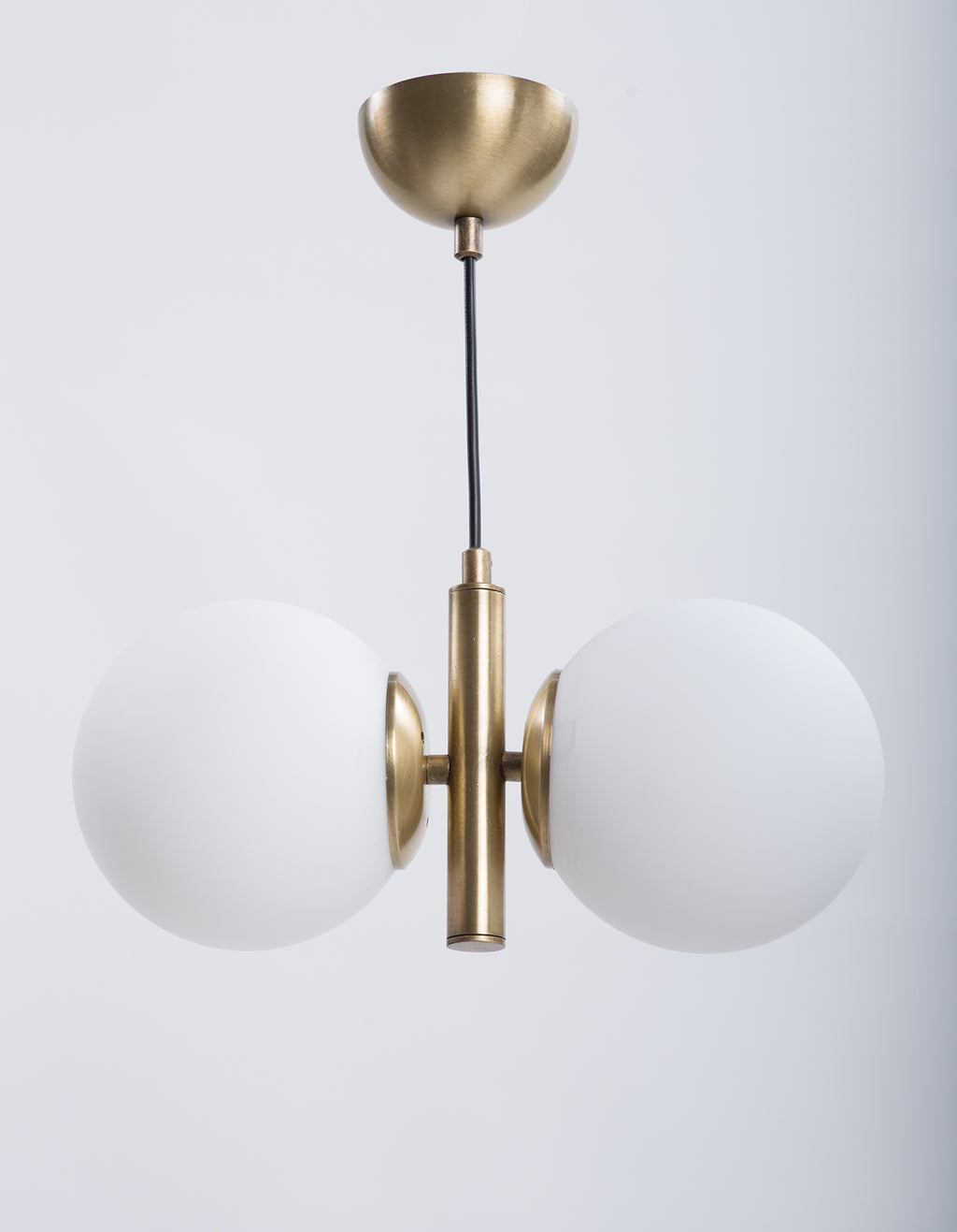 Détail des deux globes en verre blanc opale et de la structure centrale en laiton brossé