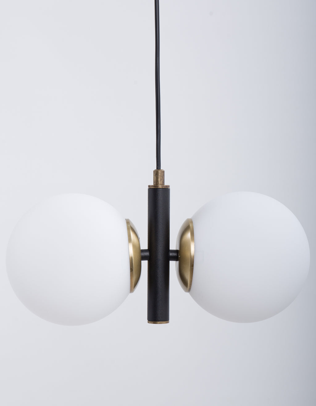 Détail des deux globes blanc opale et de la structure noire avec finition dorée