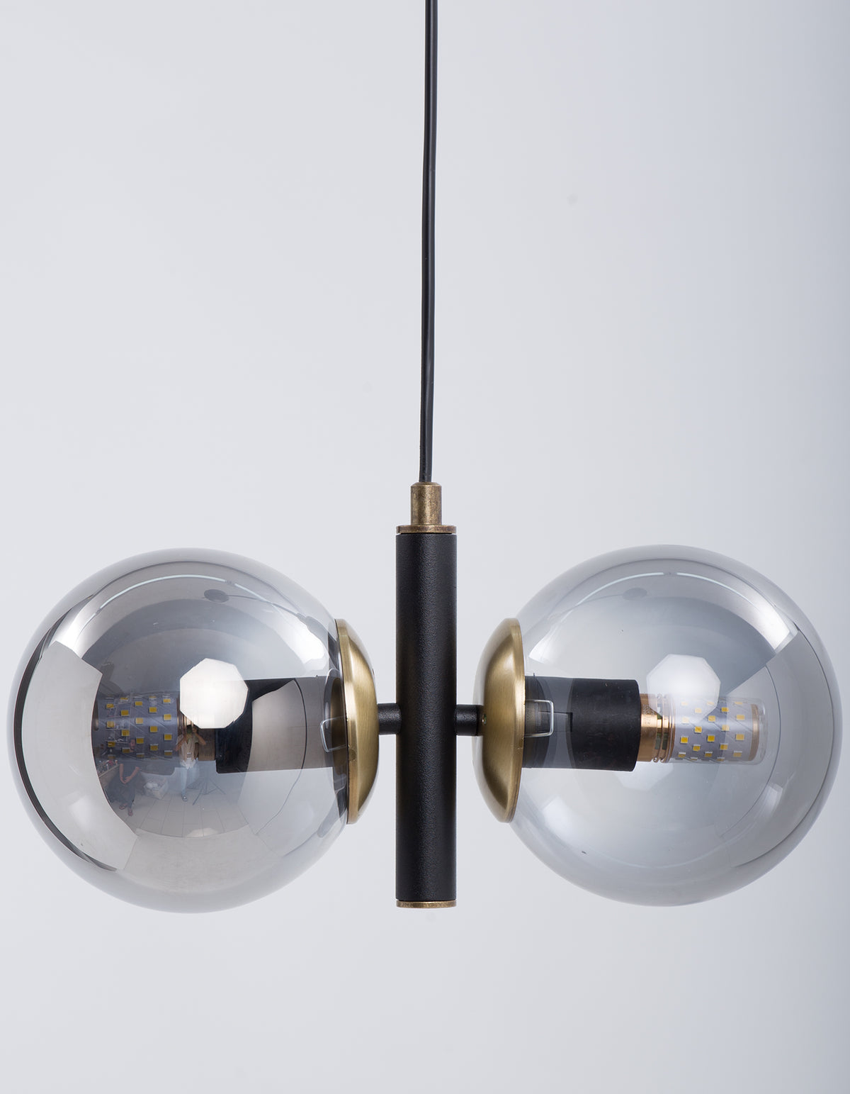 Détail des deux globes en verre fumé et de la structure noire avec finition laiton