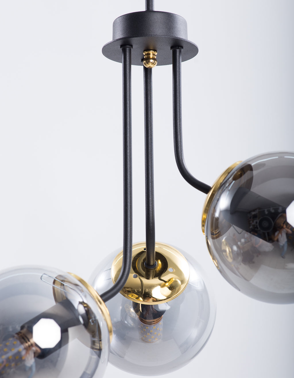 Détail des globes en verre fumé et de la structure noir mat avec détails dorés