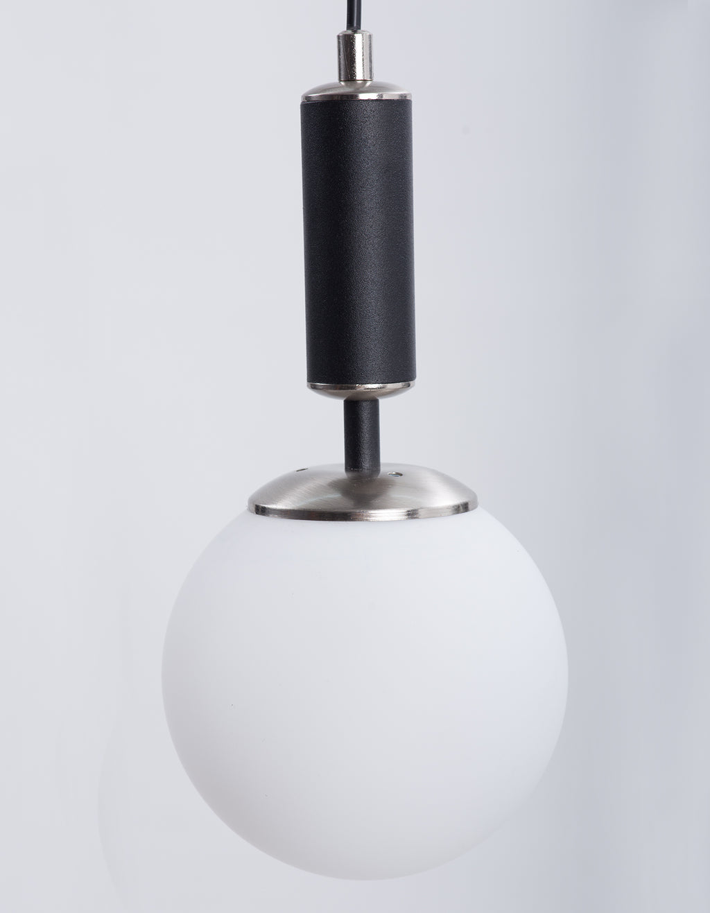 Détail du globe en verre blanc opale et de la finition chromée de la suspension
