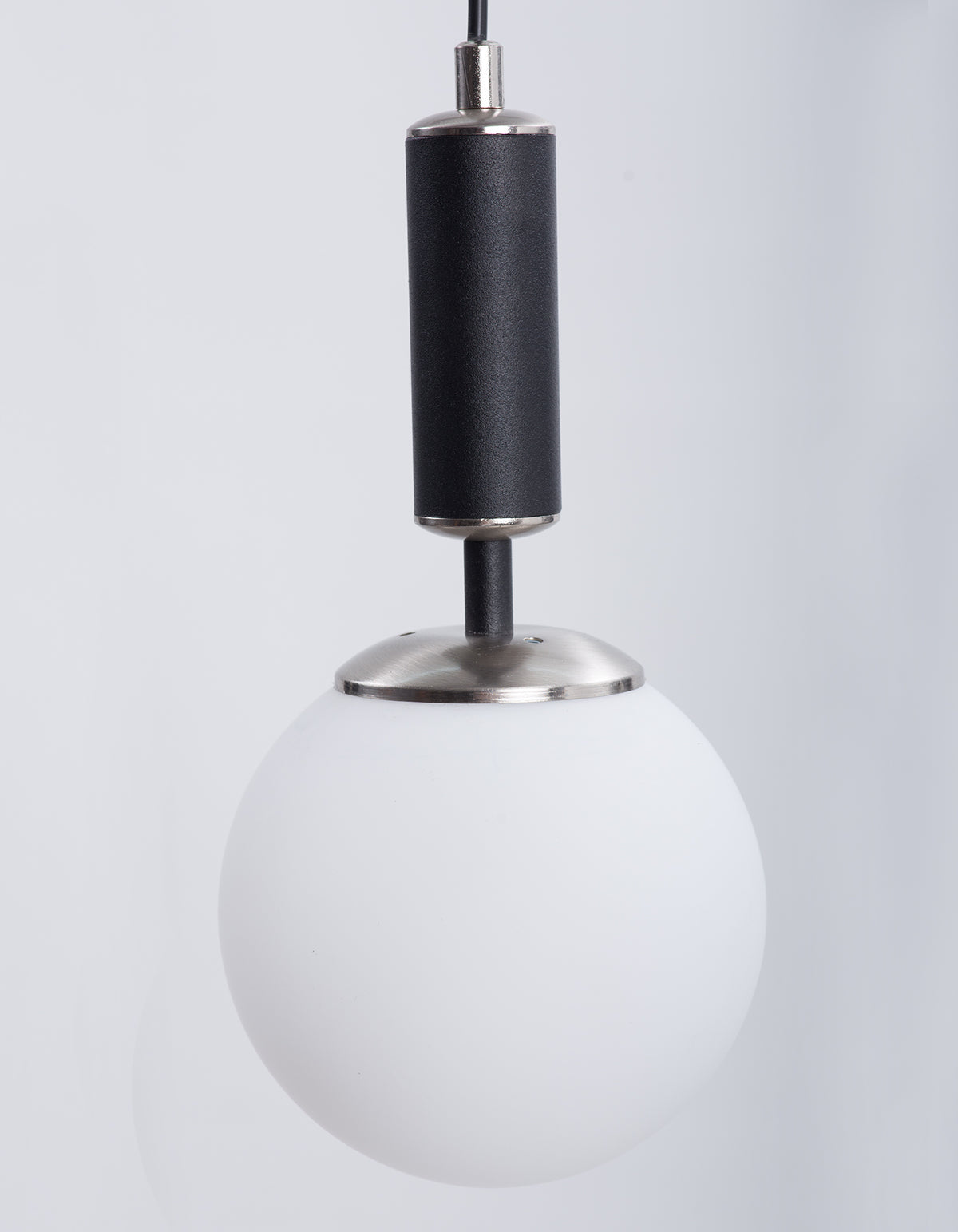Détail du globe en verre blanc opale et de la finition chromée de la suspension