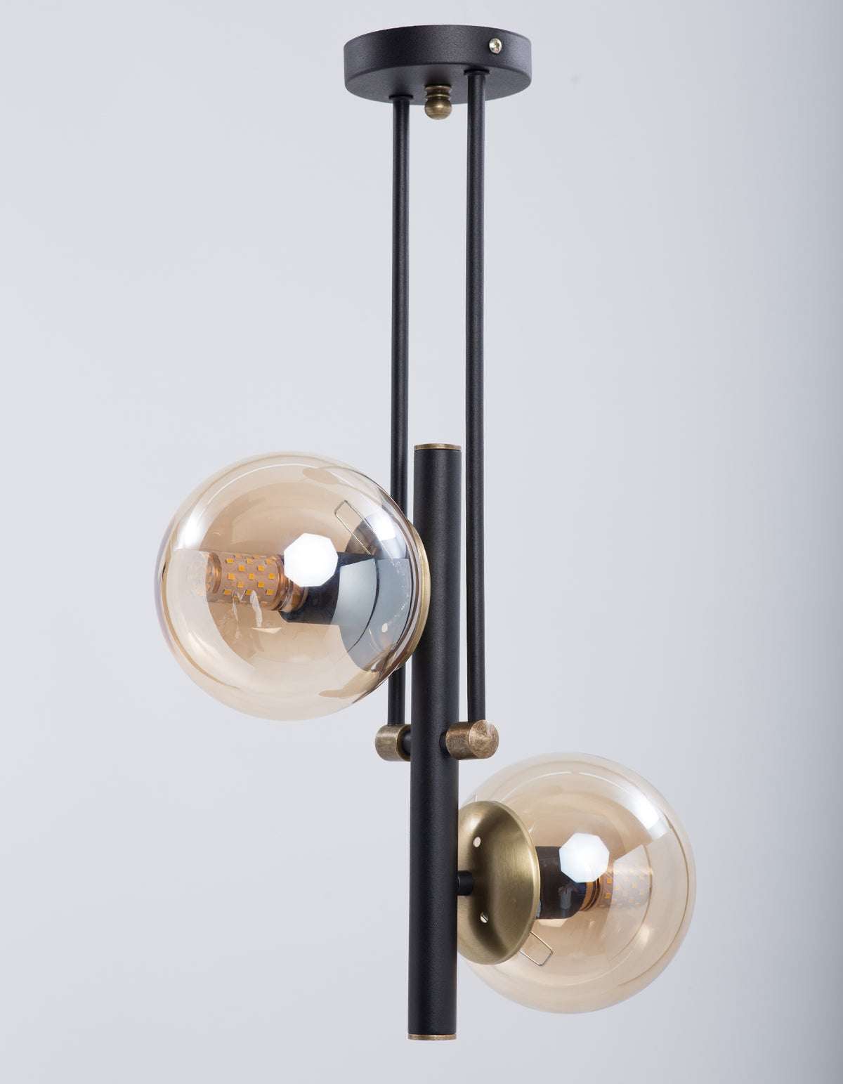 Vue latérale du lustre 2 globes ambrés avec structure noire et finitions dorées
