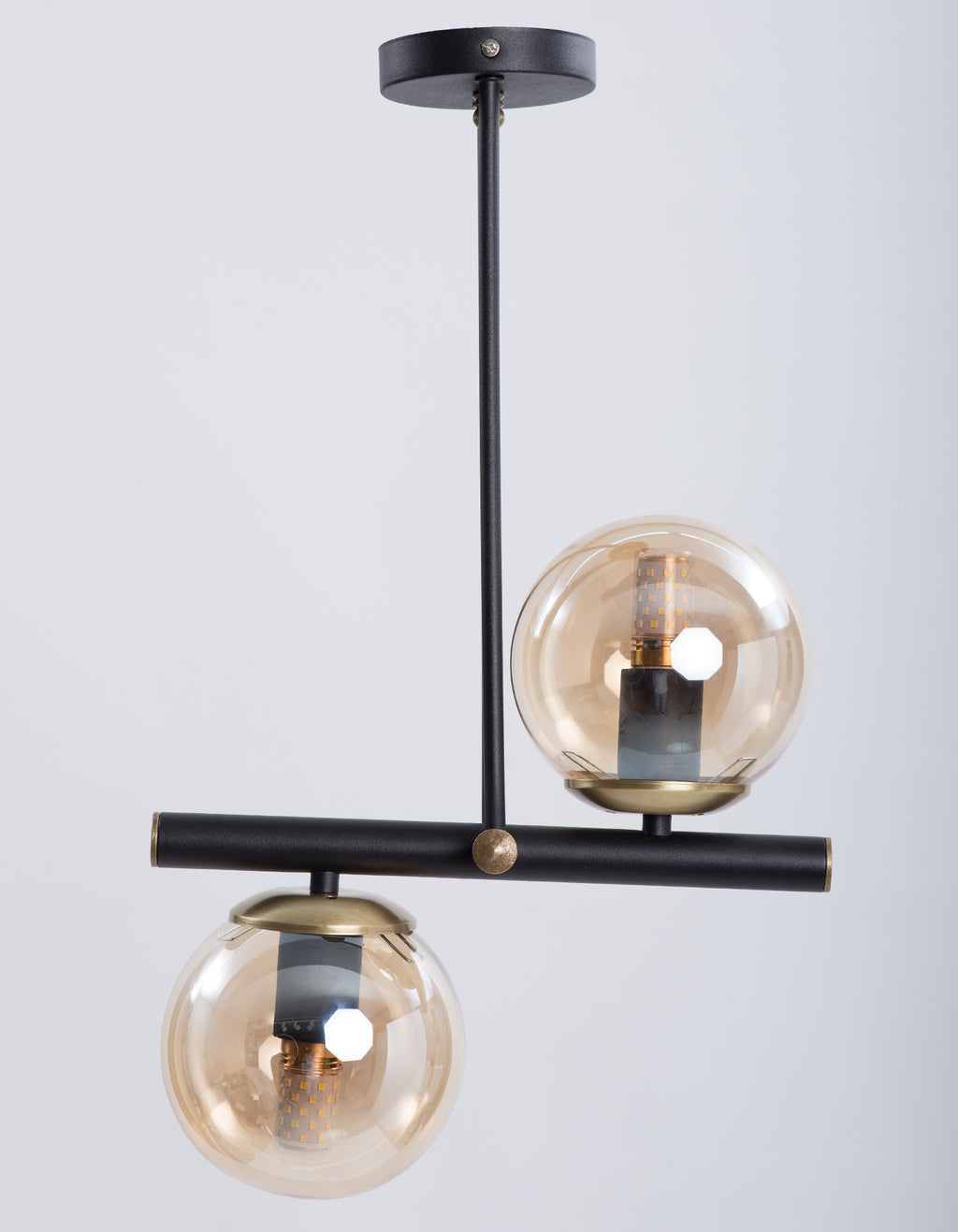 Vue de face du lustre 2 globes ambrés avec structure noire asymétrique