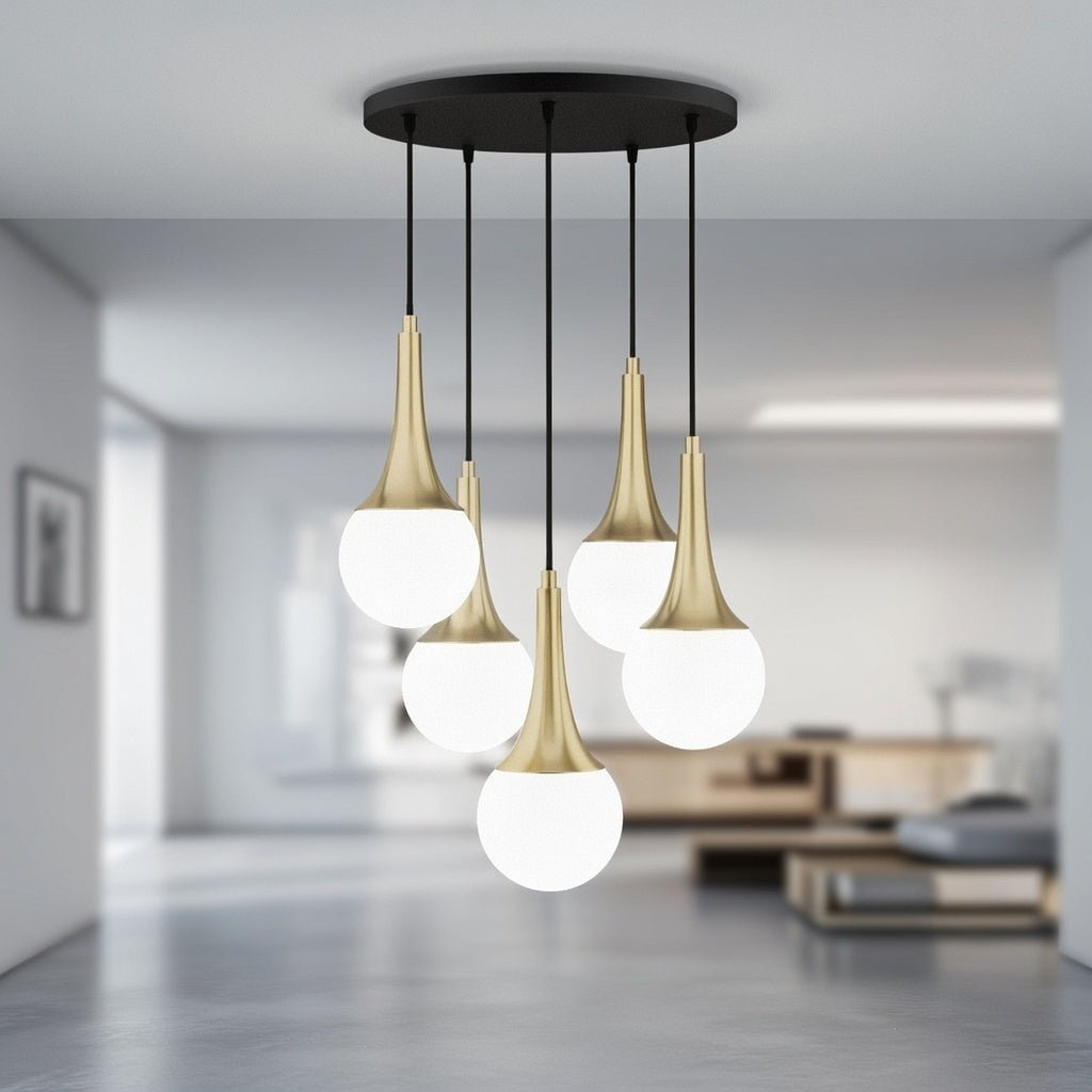 Lustre cascade 5 globes en verre blanc opale et cols dorés installé dans un intérieur lumineux