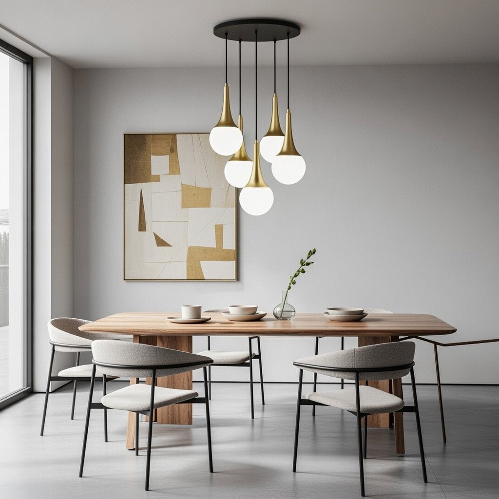 Lustre cascade 5 globes blanc opale avec cols dorés installé au-dessus d’une table à manger