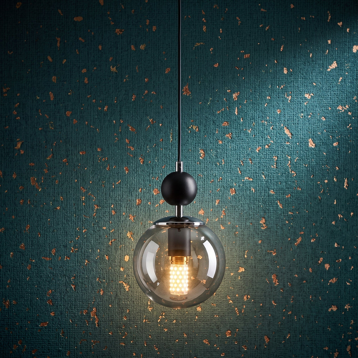 Lustre suspendu à globe en verre transparent fumé avec structure noire et détails chromés sur mur texturé