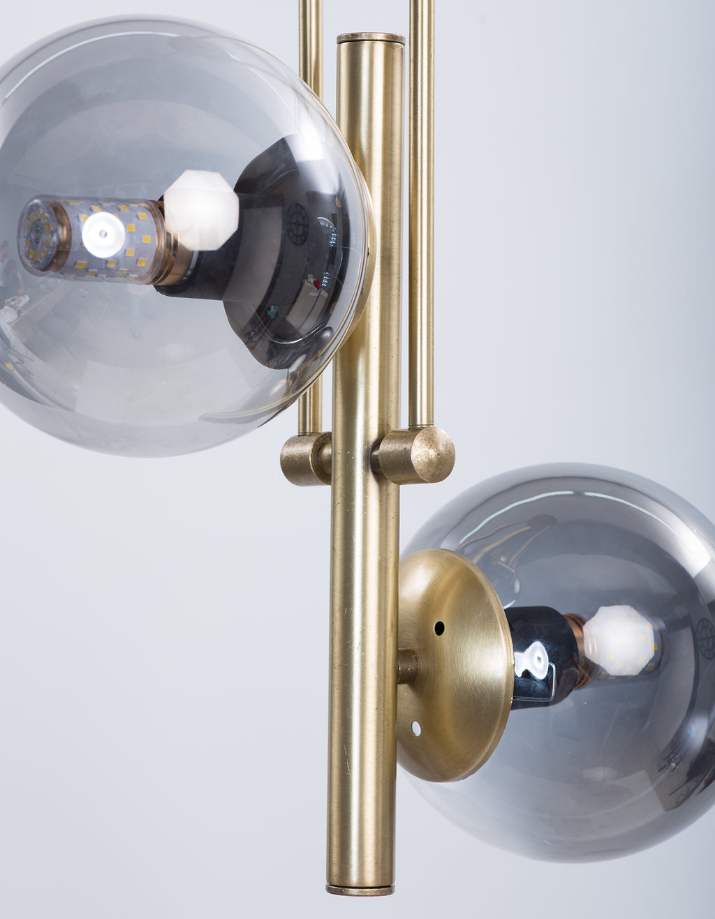 Détail de la structure dorée et des globes en verre fumé du lustre