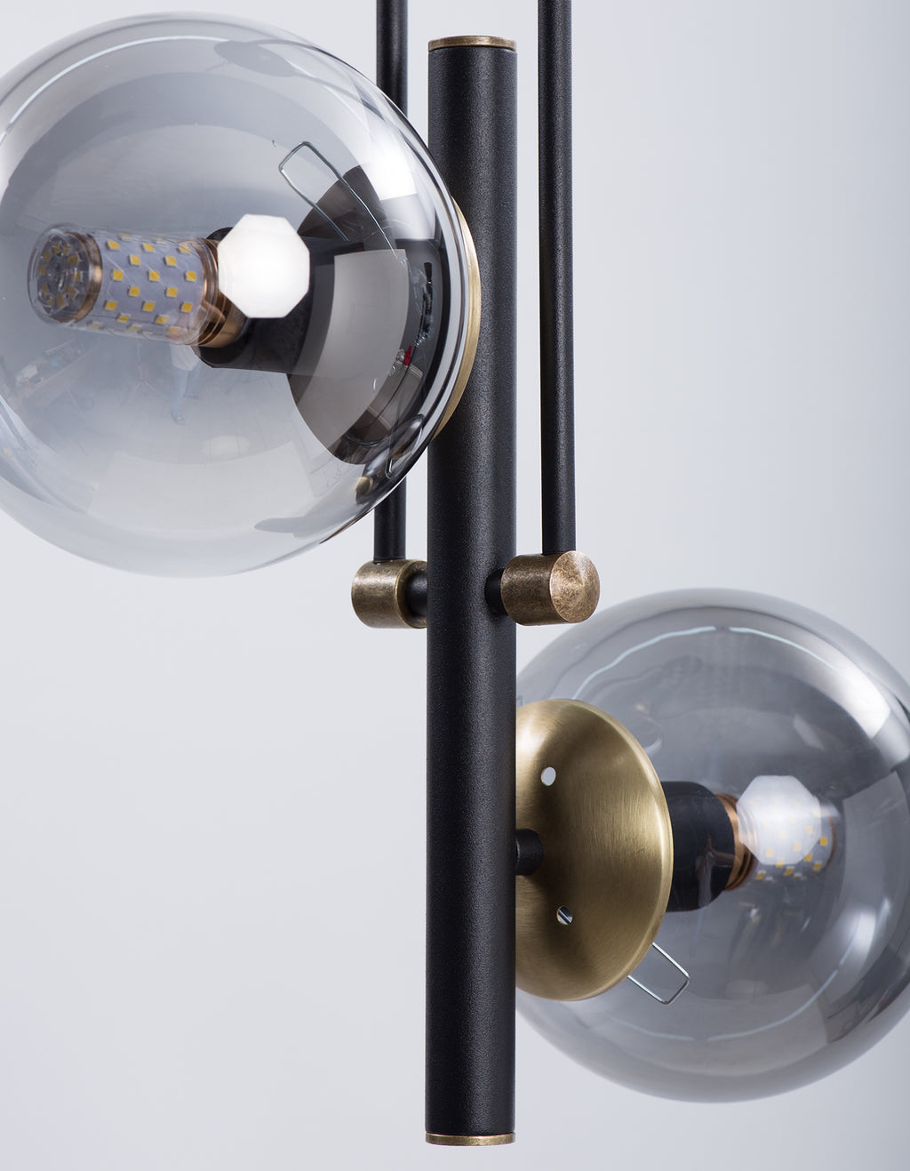 Détail des globes en verre fumé et des finitions dorées du lustre noir