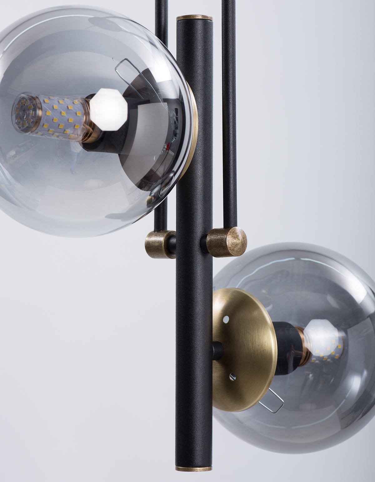 Détail des globes en verre fumé et des finitions dorées du lustre noir