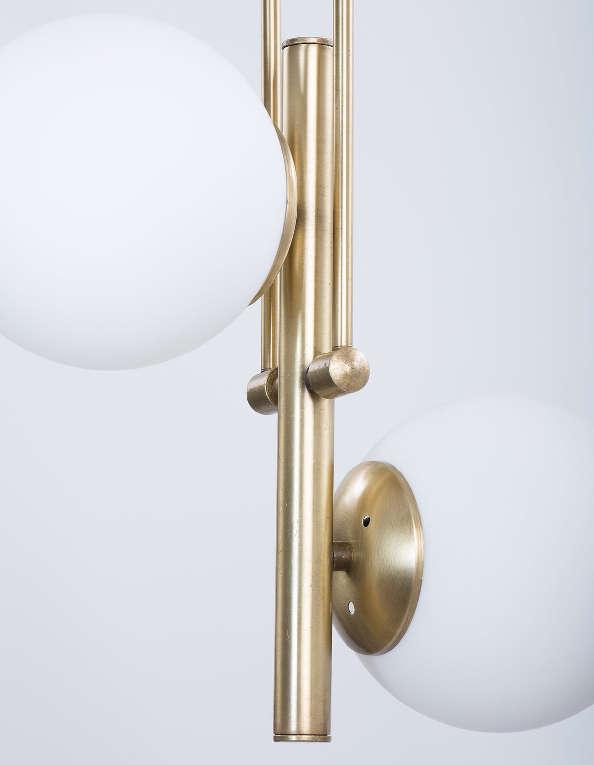Détail de la structure dorée et des globes en verre blanc opale du lustre