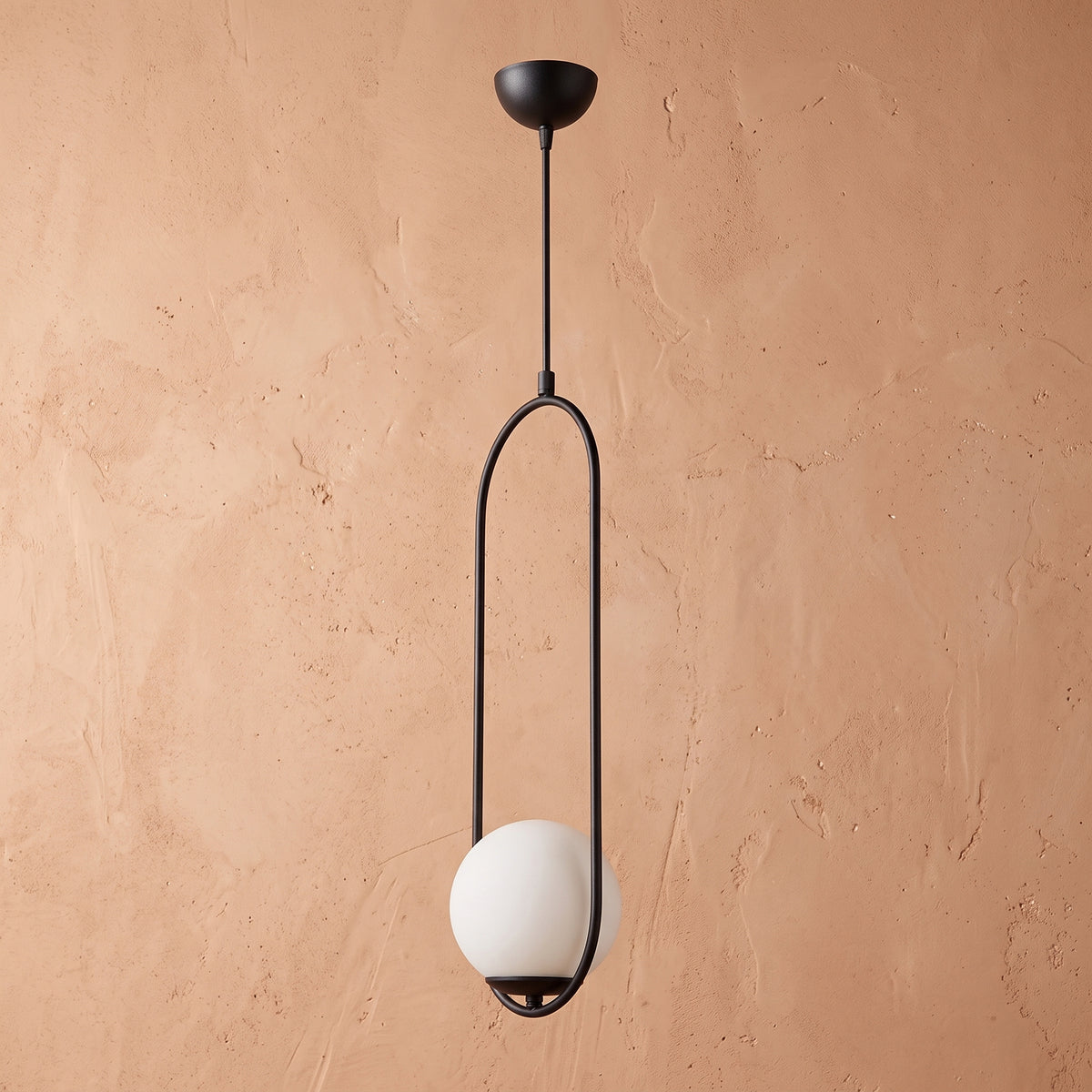 Lustre suspendu à cadre ovale noir et globe blanc opale sur mur beige texturé