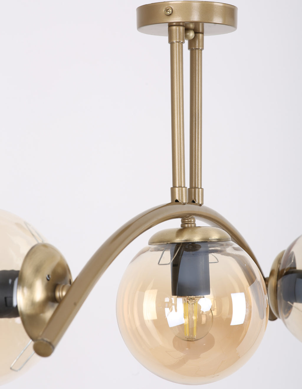 Détail de la structure en laiton doré brossé et du globe en verre ambré