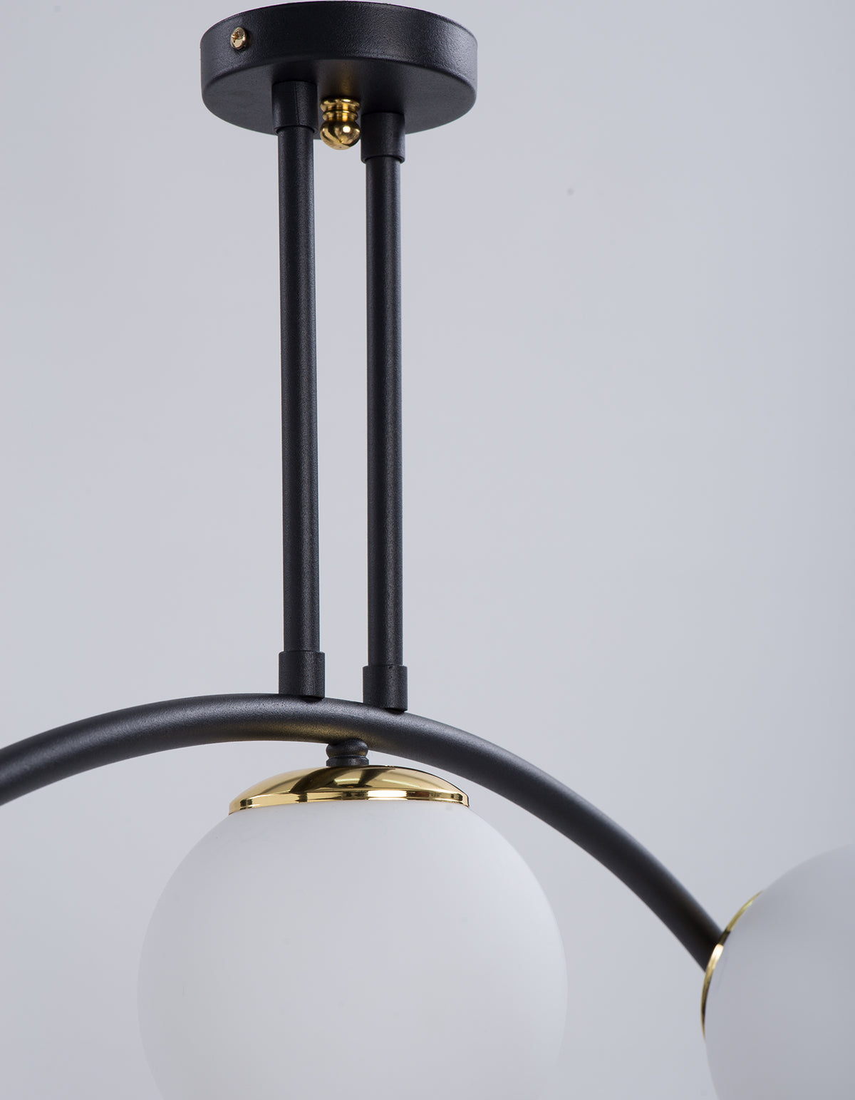 Détail de la fixation au plafond du plafonnier 3 globes blanc opale noir et doré