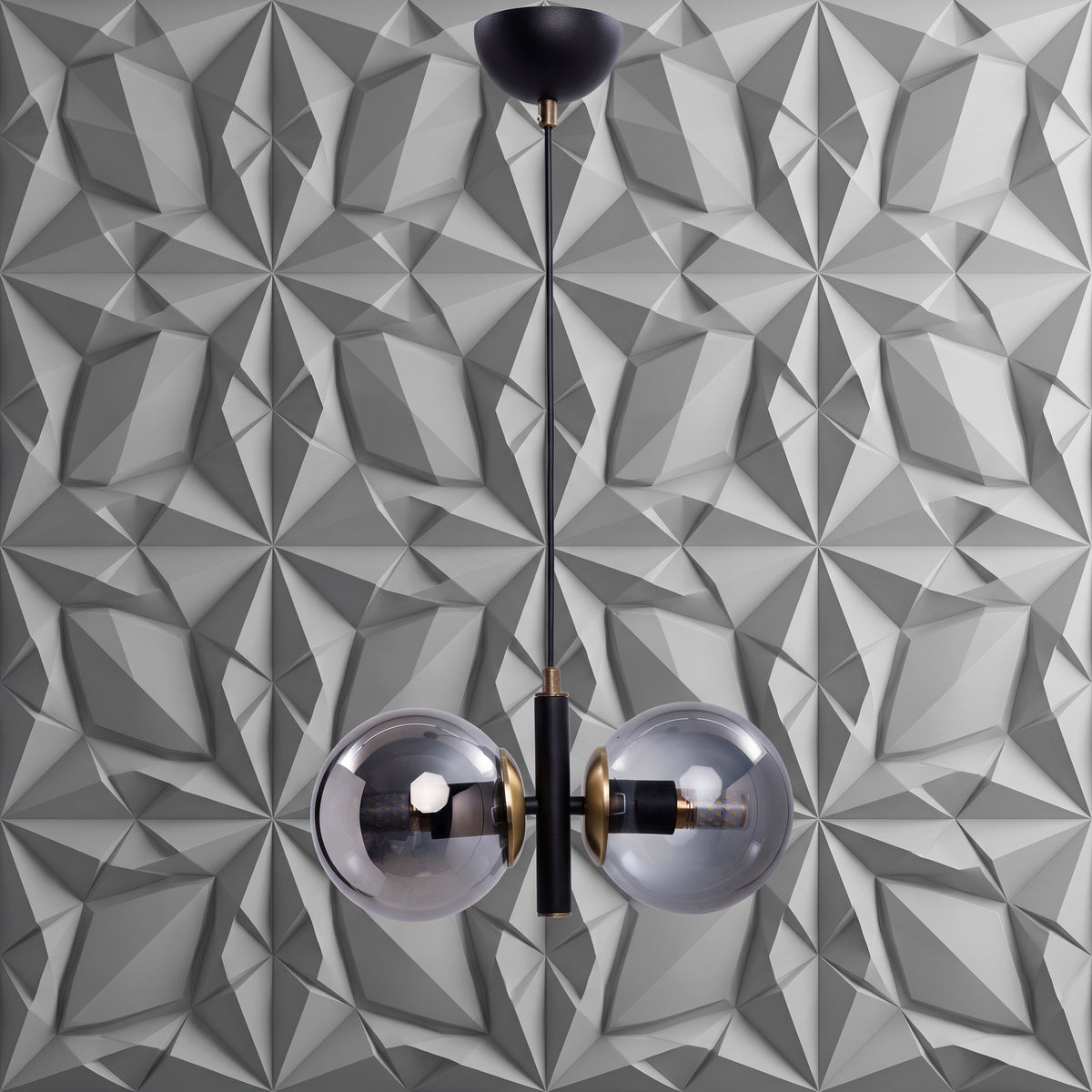 Suspension 2 globes en verre fumé transparent avec structure noir mat et détails laiton sur fond géométrique gris