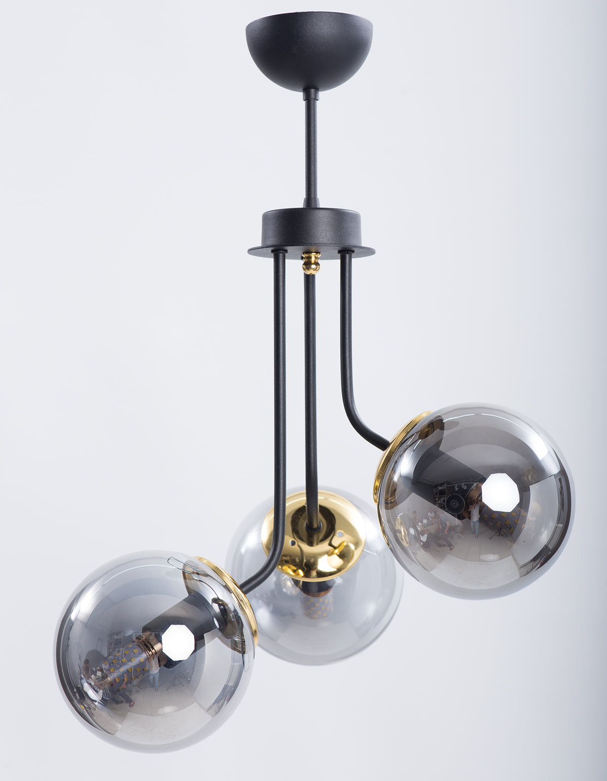Vue de face de la suspension 3 globes en verre fumé transparent avec structure noire et dorée