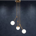 Suspension 3 globes en verre blanc opale avec bras articulés dorés sur fond bleu sombre
