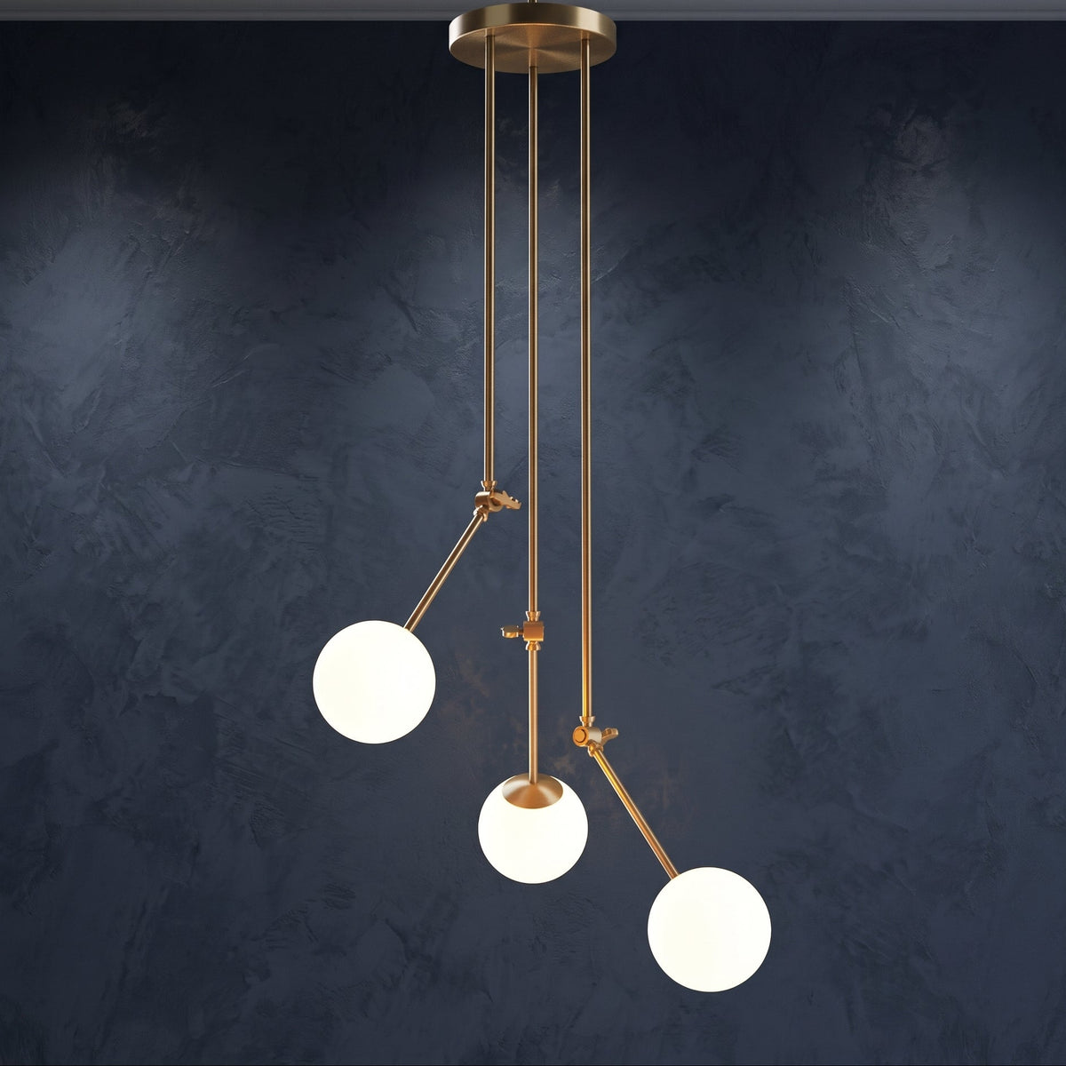 Suspension 3 globes en verre blanc opale avec bras articulés dorés sur fond bleu sombre