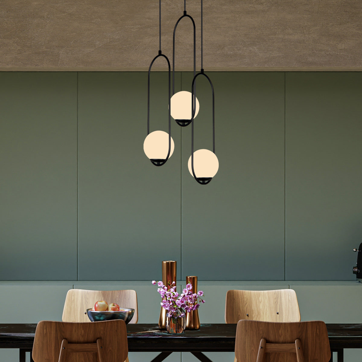 Suspension cascade 3 globes blanc opale avec arches noires installée au-dessus d’une table