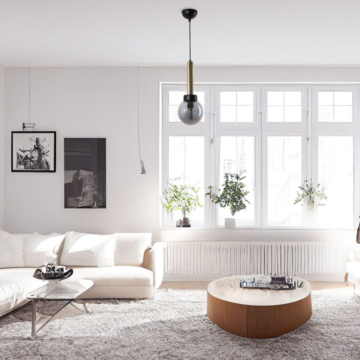 Suspension cylindre doré et globe fumé lisse installée dans un salon moderne et lumineux