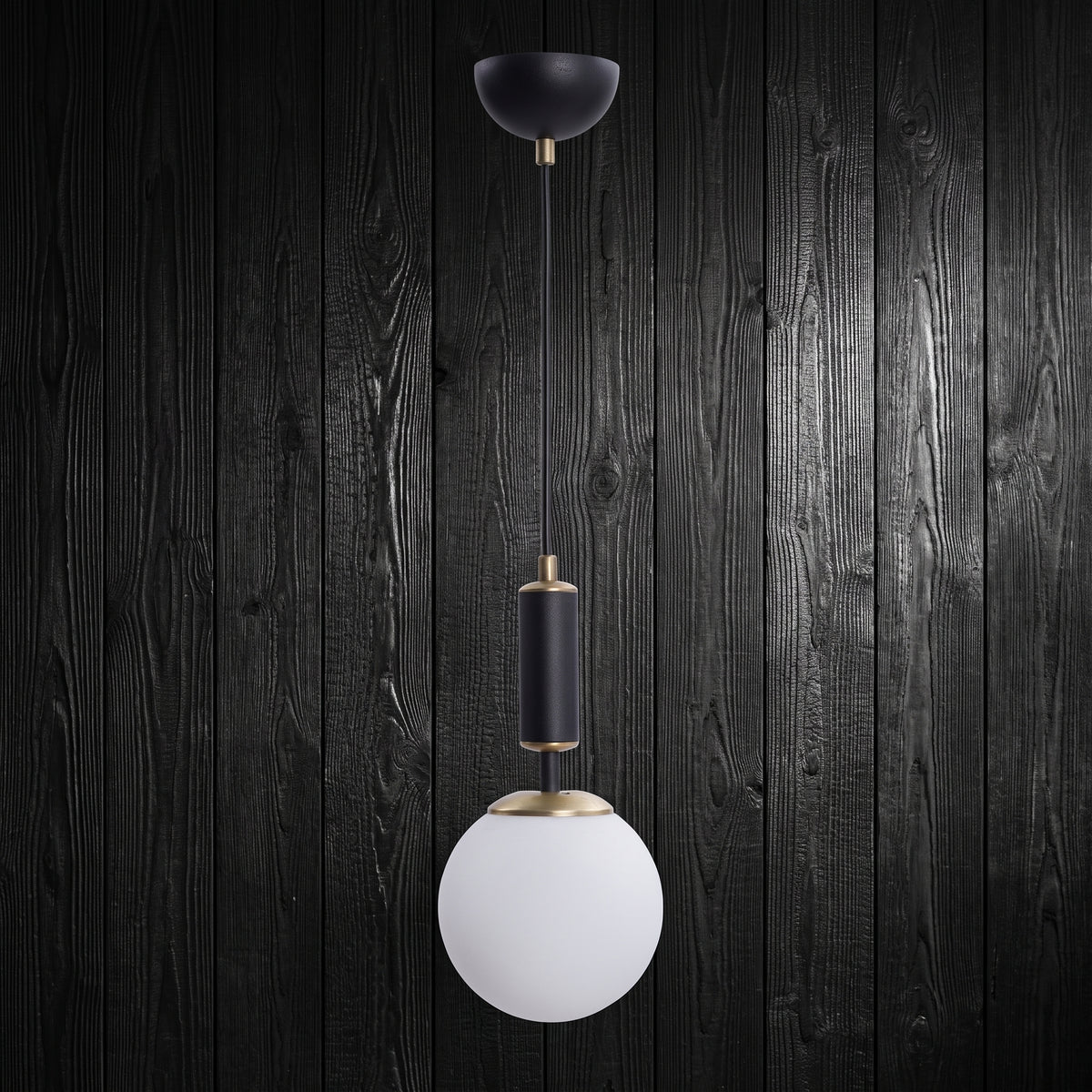 Suspension 1 globe en verre blanc opale avec cylindre noir mat et finition laiton sur fond bois sombre