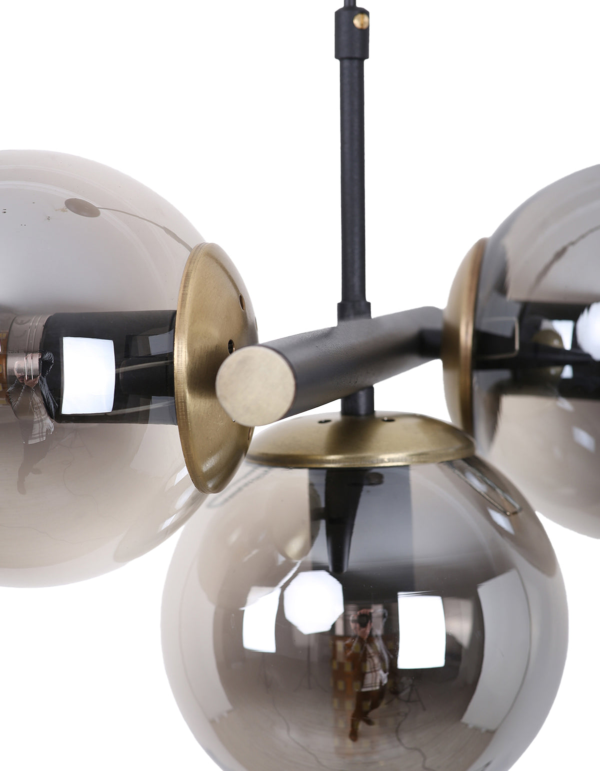Détail des globes en verre fumé, de la structure noir mat et des finitions dorées